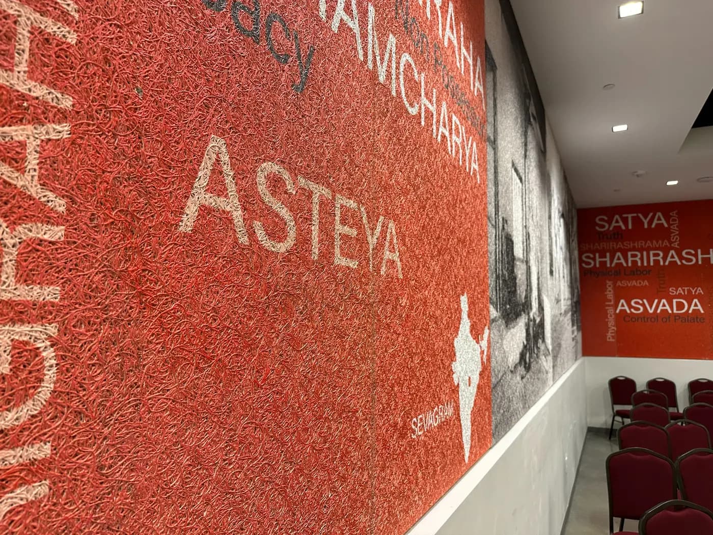 Printed red and black Tectum mural panels wrapping the Eternal Gandhi Museum auditorium
