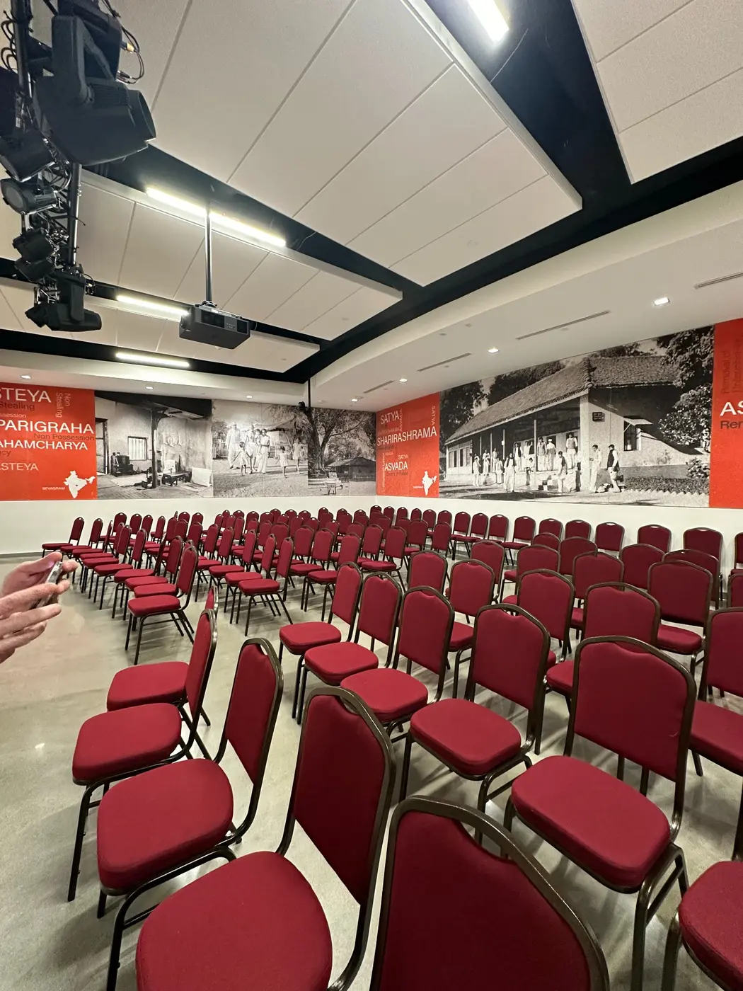 Full auditorium with red seating and printed acoustic wall panels