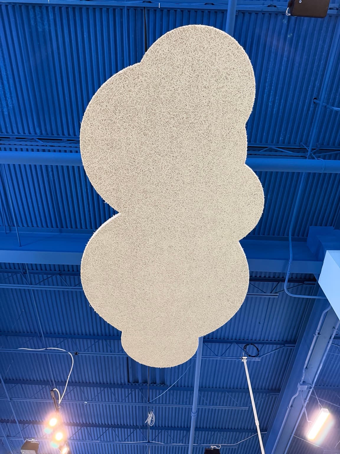 Close view of a cloud-shaped Tectum® panel and its textured surface against the blue ceiling
