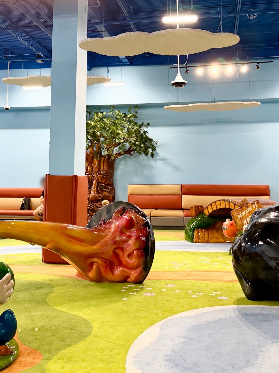 Textured cloud-shaped Tectum® panels suspended above perimeter seating and soft-play structures