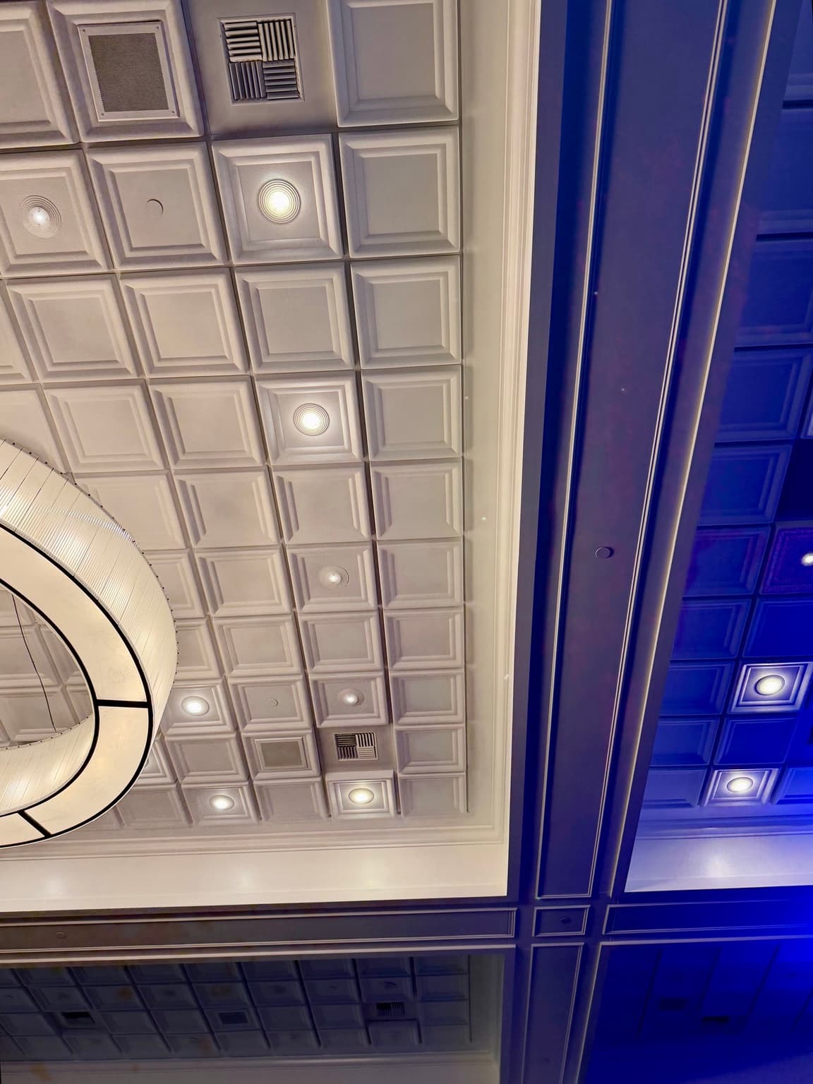 Close view of white recessed ceiling tiles and integrated lights